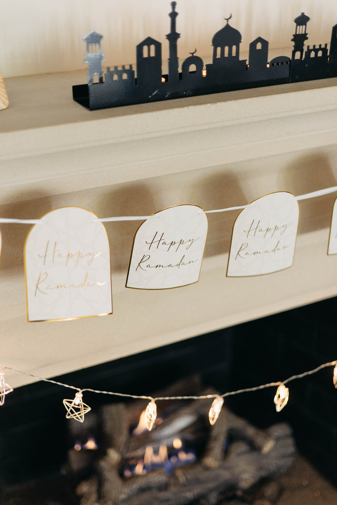 Decorative setup with 'Happy Ramadan' signs and string lights on a fireplace. Ramadan Arches Banner; Ramadan Decorations; Party; Decor; Islamic Decor; Muslim Decor; Happy Ramadan; Jerusalem; Modern; Gold; Elegant; Arch Banner